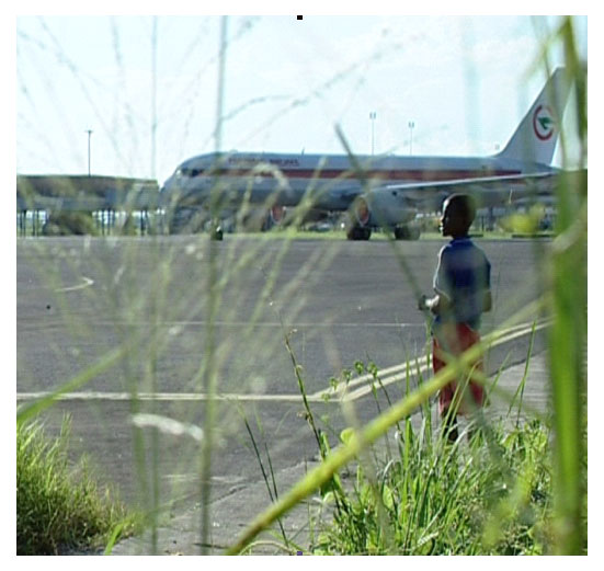 ein Junge steht auf dem Rollfeld des Flughafens Douala